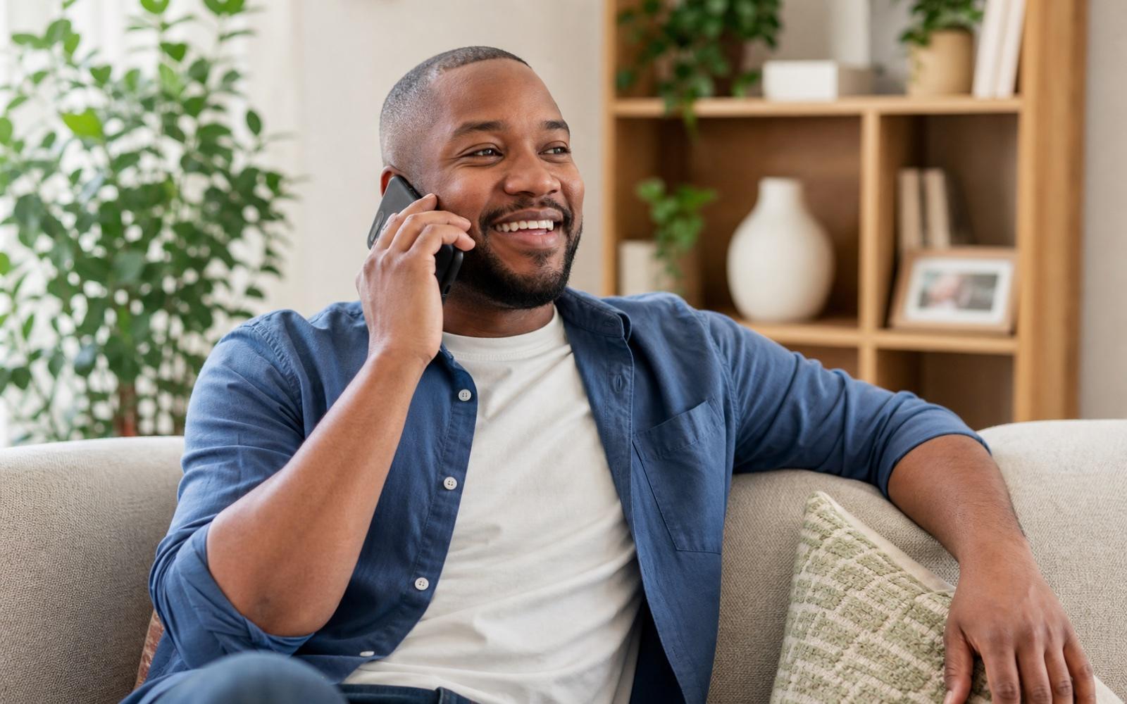 A person smiling while calling someone on a smartphone